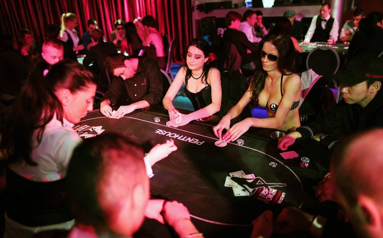 A group of players at a strip poker table, engaged in a game, with a vibrant and lively casino ambiance featuring a mix of formal and casual attire.